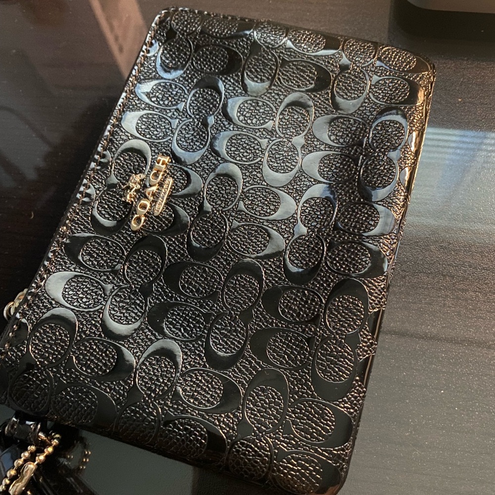 Coach, shiny, black wristlet wallet.